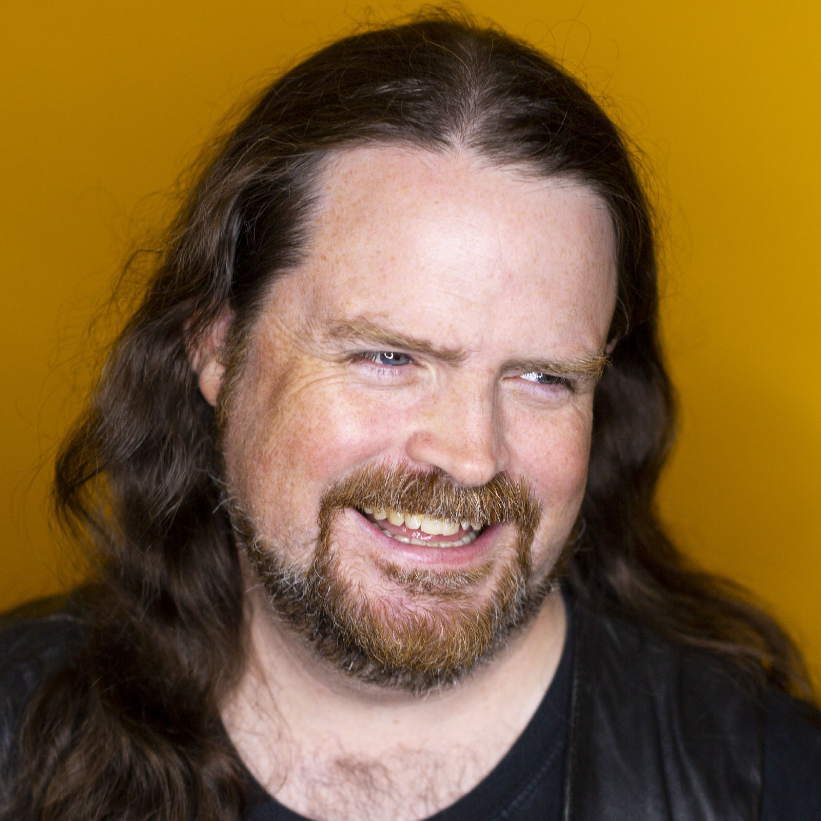 Studio headshot of Dylan Beattie in front of a yellow background.